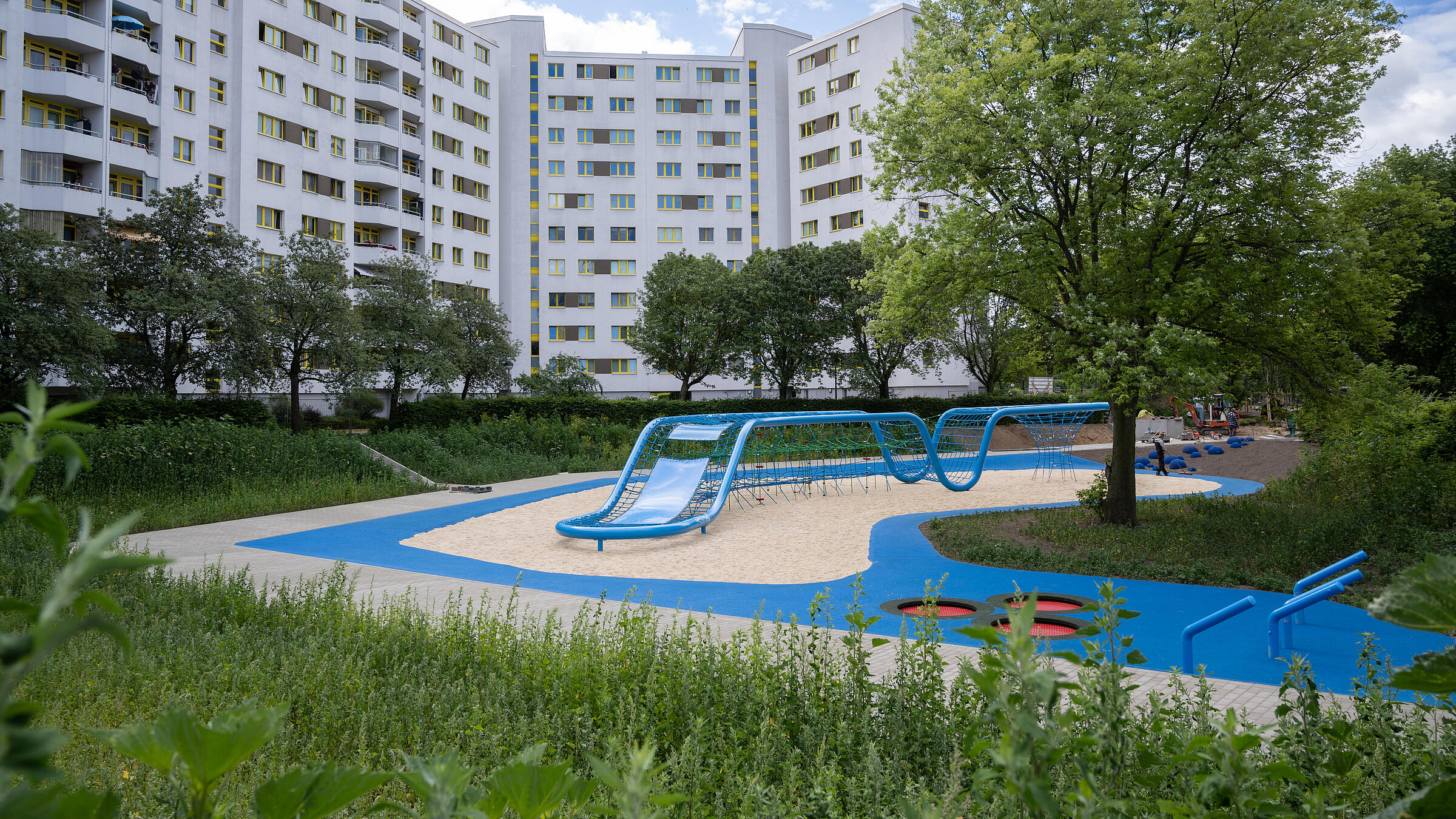 Aufnahme Außenanlage zeigt den neugestalteten Spielplatz "Wasserschlucht". Im Hintergrund Wohnhäuser der Quickborner Straße.