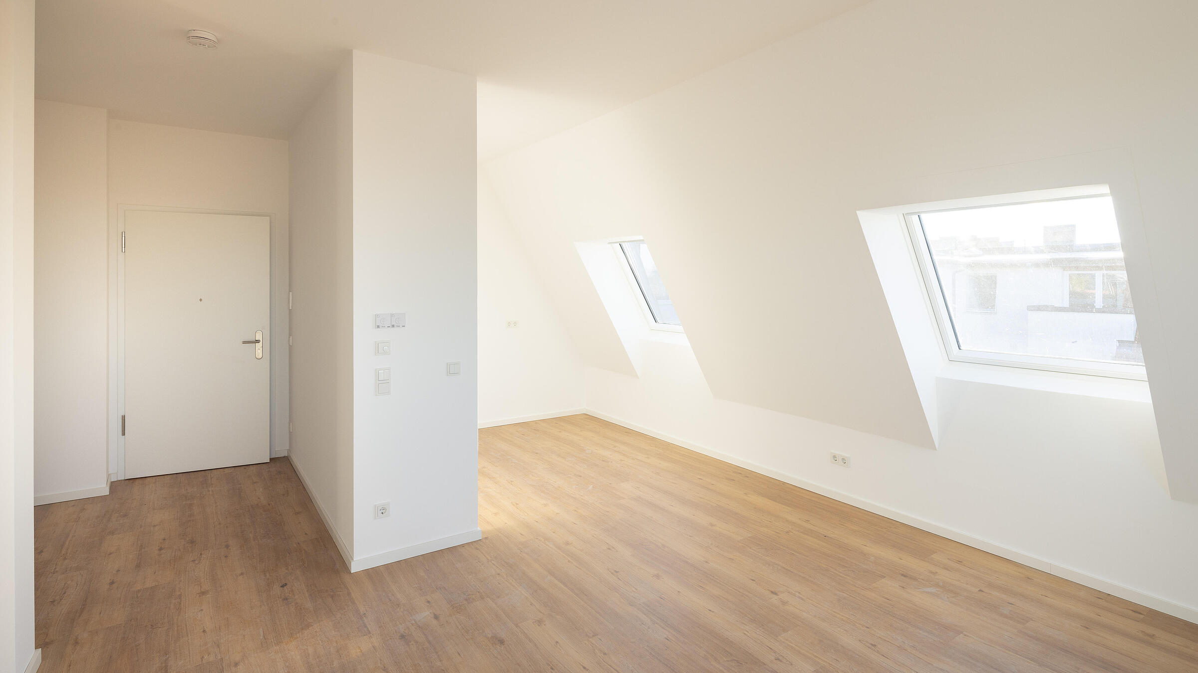 Bild zeigt Musterwohnung im Dachgeschoss der Uhlandstraße 70: Blick aus dem Wohnzimmer Richtung Wohnungseingangstür.