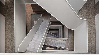 Blick von oben nach unten durch das modern gestaltete Treppenhaus in der Finsterwalder Straße 102A.