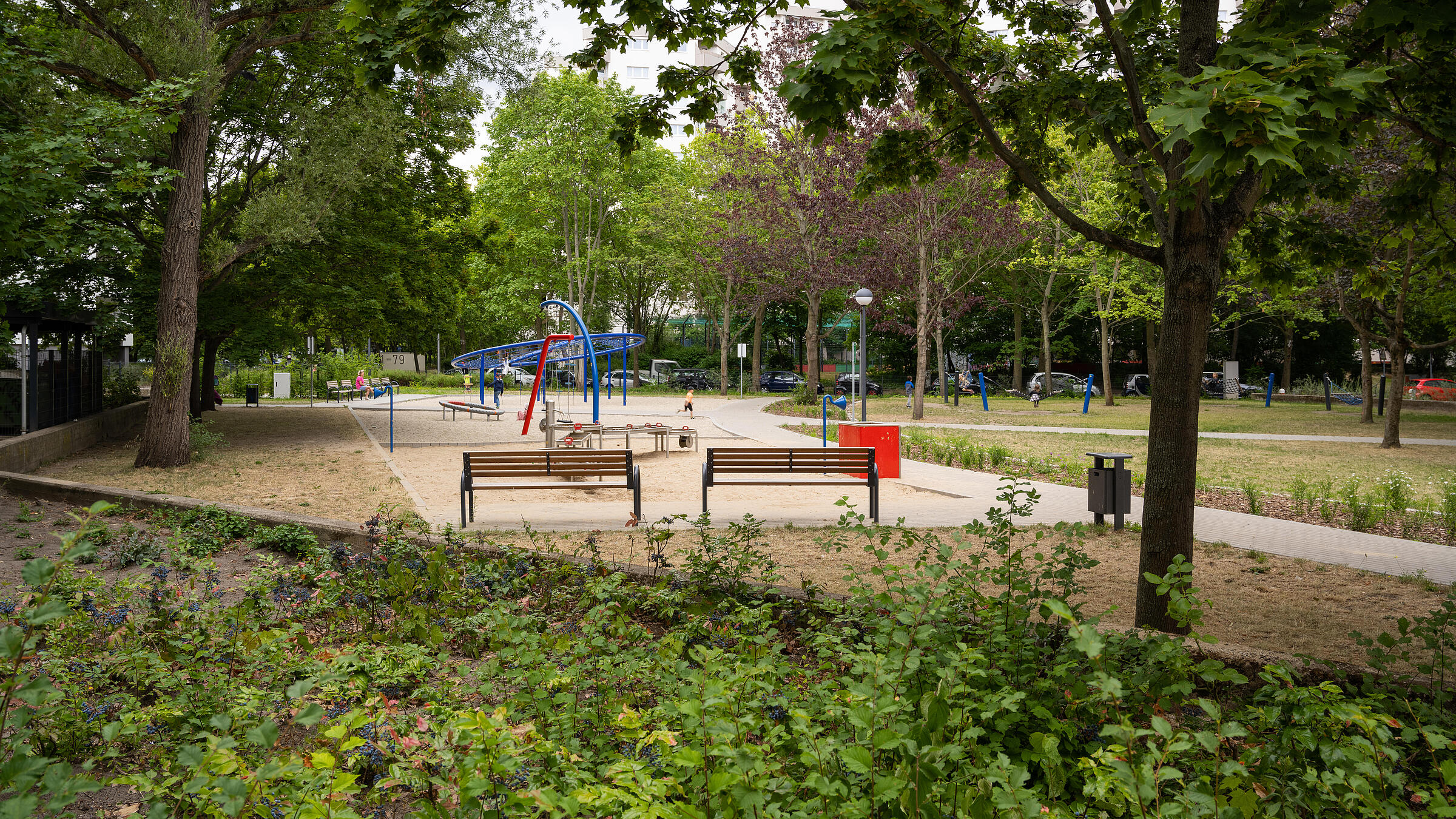 Außenaufnahme Gesamtüberblick neuer Spielbereich zwischen Senftenberger Ring und Finsterwalder Straße, umgeben von Grünflächen.