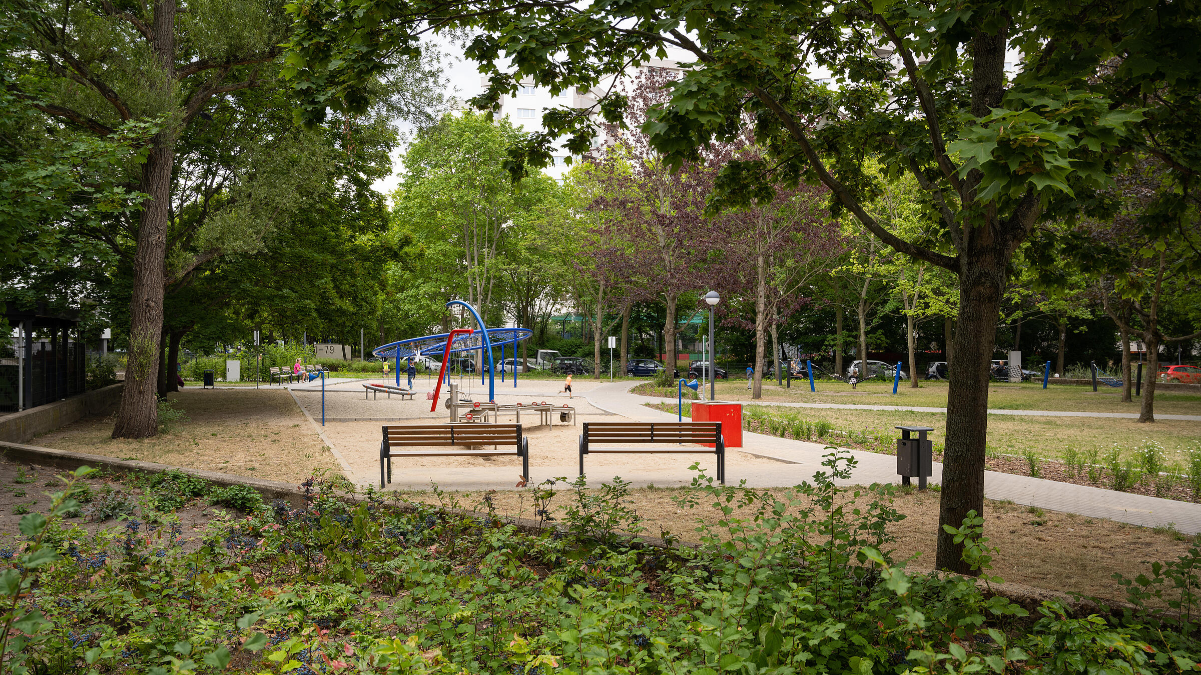 Außenaufnahme Gesamtüberblick neuer Spielbereich zwischen Senftenberger Ring und Finsterwalder Straße, umgeben von Grünflächen.