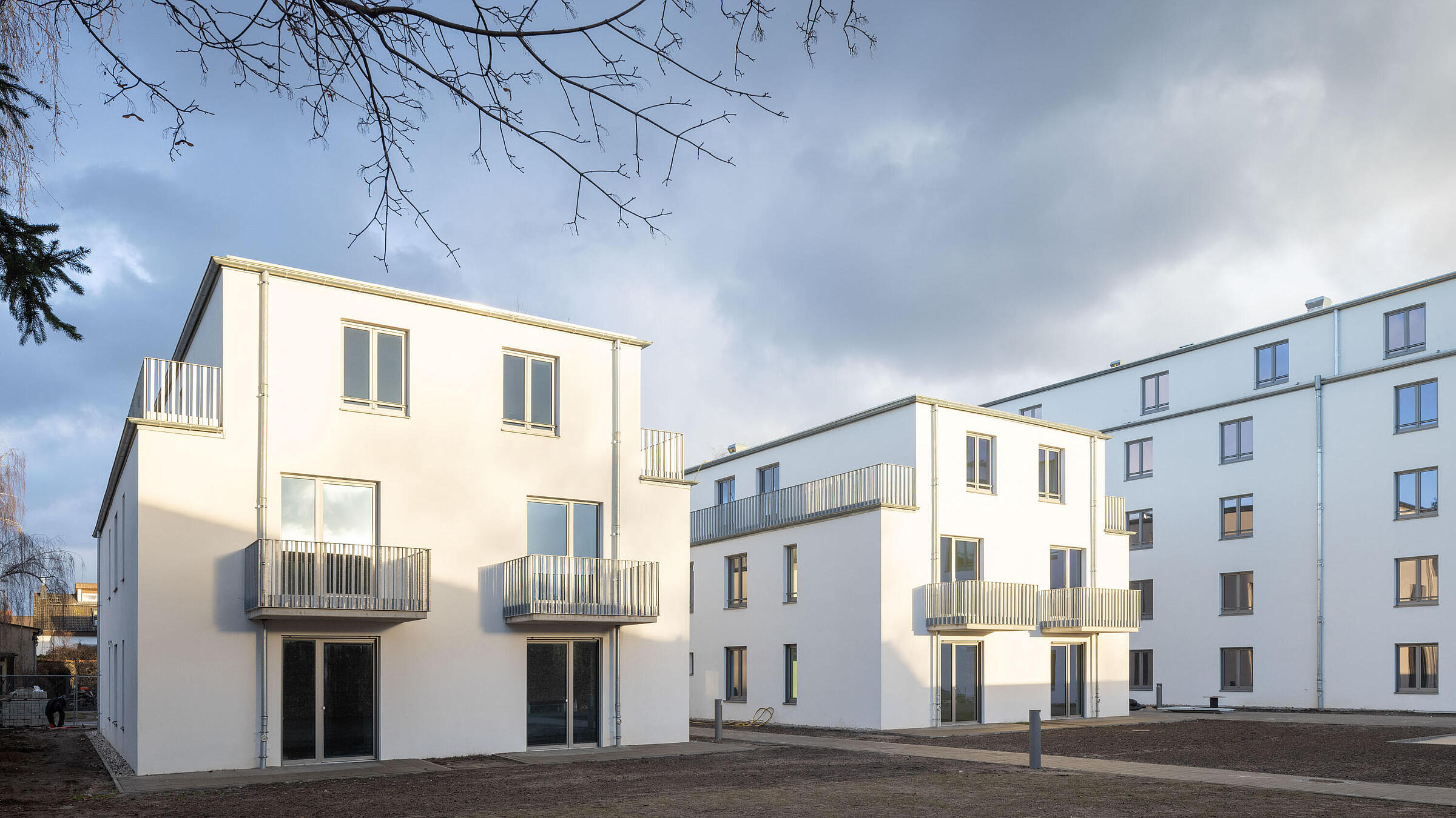 Außenaufnahme zeigt zwei dreigeschossige, neu gebaute Wohnhäuser.