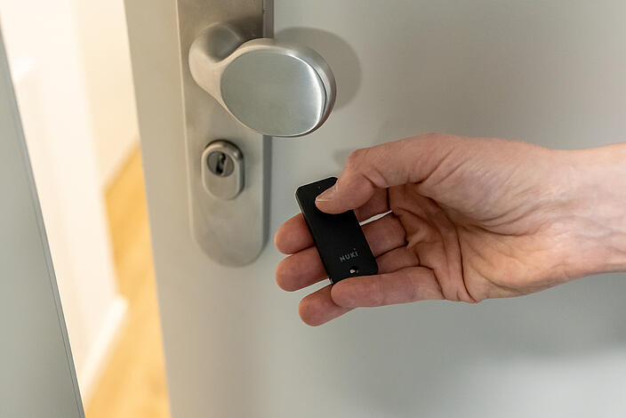 Ein Türschloss wird per Knopfdruck mit einer kleinen Fernbedienung geöffnet