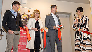 Vier Personen schneiden ein Eröffnungsband durch.