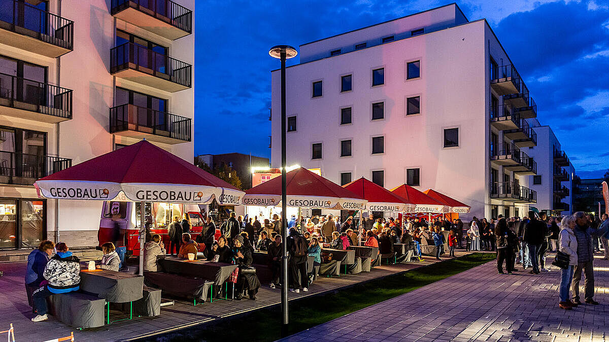 Menschen auf der Veranstaltung "Berlin leuchtet" umgeben von Neubauten