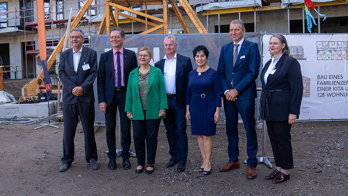 Bild zeigt Redner*innen beim Richtfest des FACE Campus  (v.l.): Thomas Harms (Superintendent Kirchenkreis Reinickendorf), Senator Christian Gaebler (Senator für Stadtentwicklung, Bauen und Wohnen), Ulrike Trautwein (Generalsuperintendentin von Berlin), Christian Wilkens (Vorstand GESOBAU AG), Emine Demirbüken-Wegner (Bezirksbürgermeisterin von Reinickendorf), Albert Ten Brinke (Geschäftsführer von Ten Brinke) und Ute Strelow (Projekt- und Immobilienentwicklung)