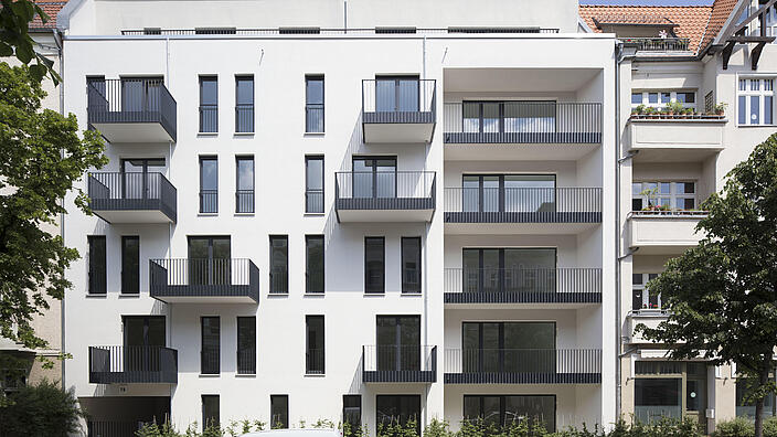 Straßenansicht des neu errichteten Mehrfamilienhauses mit Balkonen