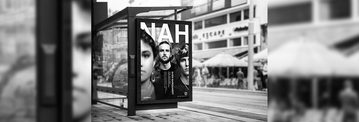 Ausstellungsplakat "Nah" mit jungen Menschen in der Nahaufnahme hängt an einer Bushaltestelle