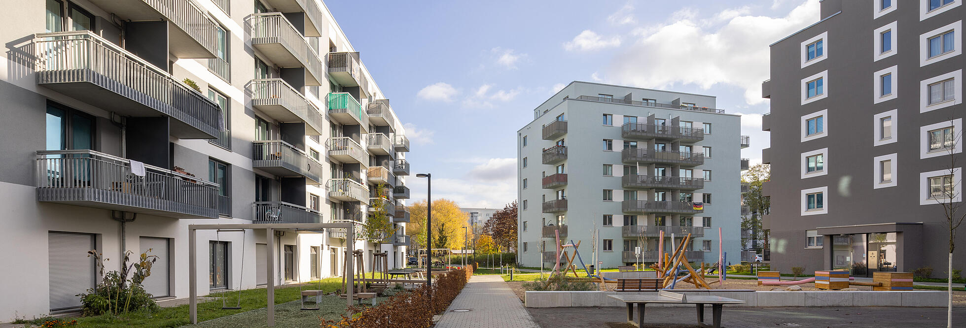 Außenaufnahme zeigt einen Blick in einen Weg entlang drei neu gebauter WOhngebäude im Stadtgut Hellersdorf