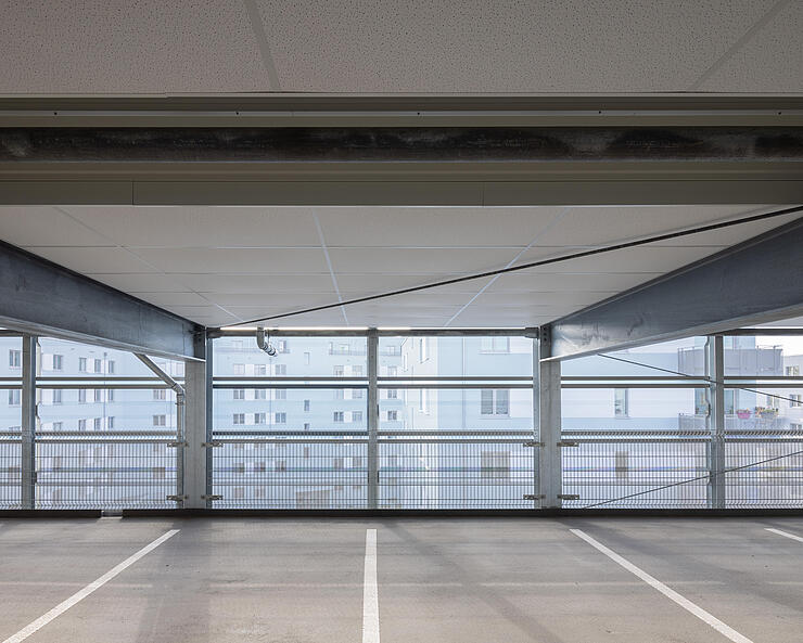 Innenaufnahme eines modernen Parkhauses, zu sehen sind leere Stellplätze