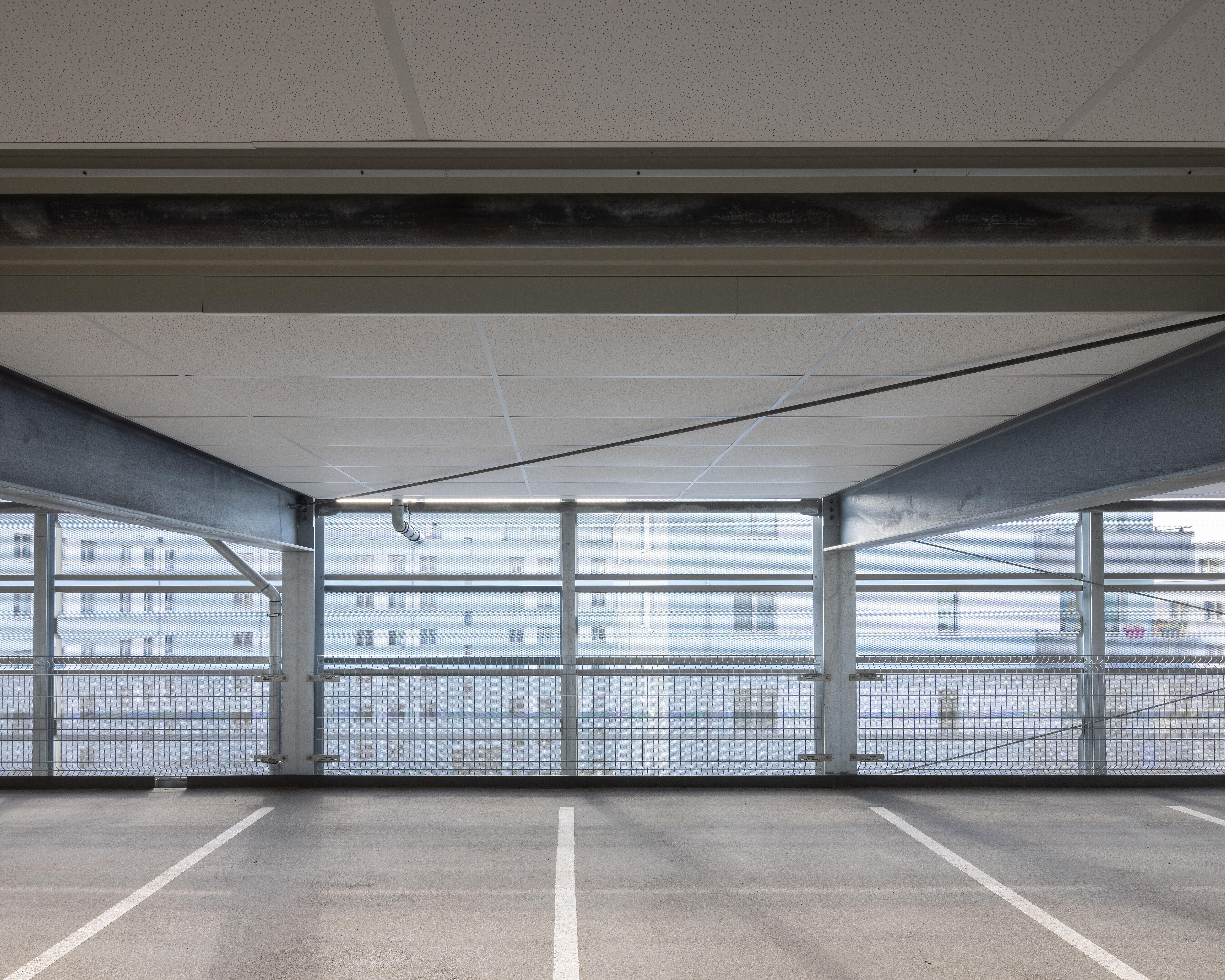 Innenaufnahme eines modernen Parkhauses, zu sehen sind leere Stellplätze