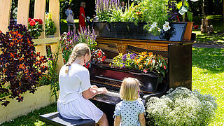 Kinder spielen an meinem bepflanzten Klavier