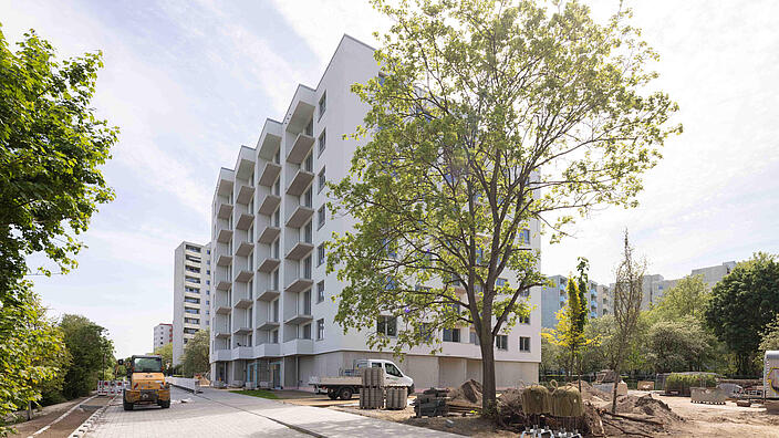 Außenaufnahme aus dem Juni 2022: Der fast fertiggestellte Neubau in der Finsterwalder Straße von der Seite aus fotografiert, vor der Fassade ein Baum. 