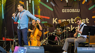 Jazz-Sänger singt auf einer Bühne, Band spielt auf Instrumenten