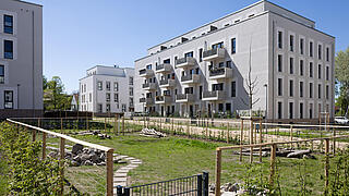 Grüne Wiese, im Hintergrund moderne Neubauanlage in der Beate-Hahn-Straße und Marianne-Foerster-Straße.