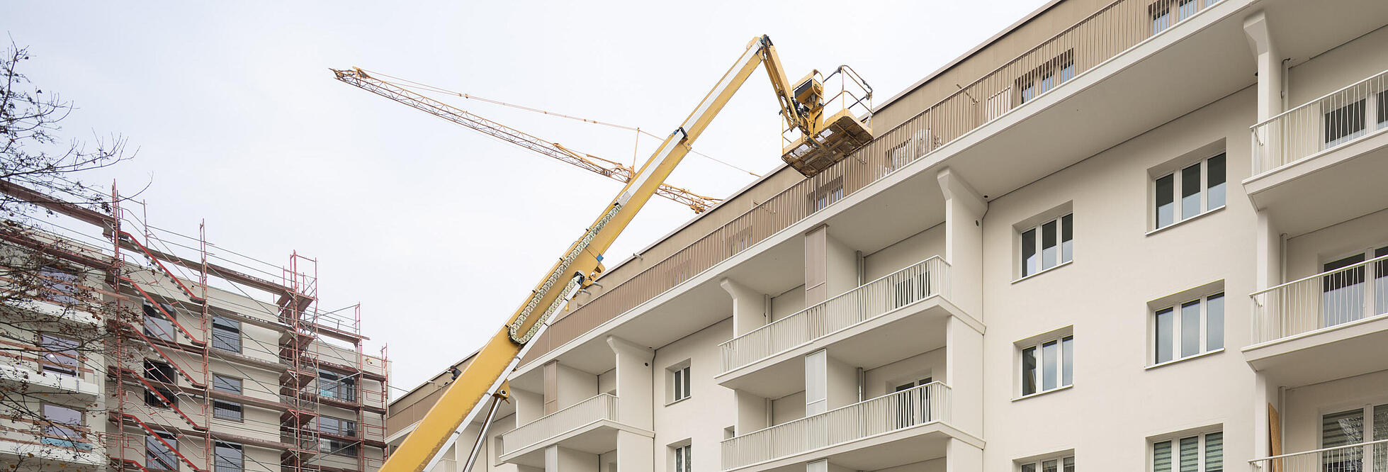 Außenaufnahme zeigt einen kleinen Kran vor dem frisch modernisierten Wohnhaus im Stiftsweg.