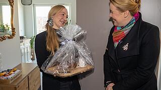 Franziska Giffey, Regierende Bürgermeisterin von Berlin, überreicht Brot und Salz an eine Neumieterin.
