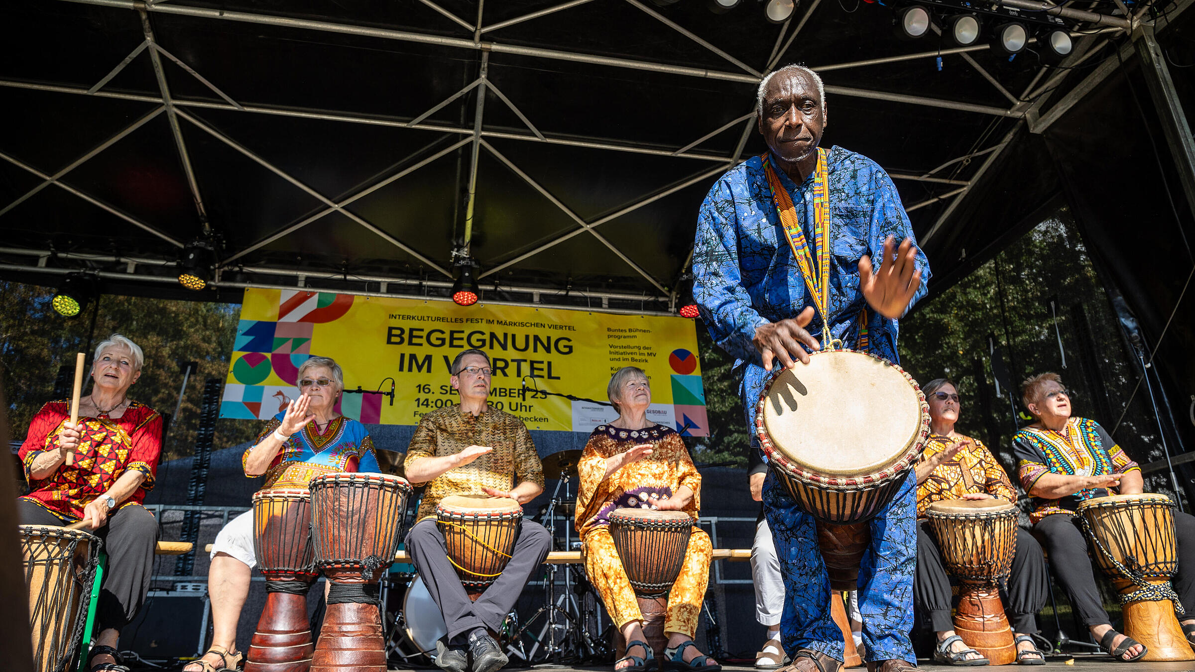 Außenaufnahme zeigt eine Gruppe trommelnder Musiker*innen auf der Hauptbühne des Begegnungsfests 2023.