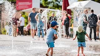 Kinder springen im Wasserspiel herum
