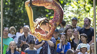 Junge Zirkusakrobatin zeigt Kunststücke.