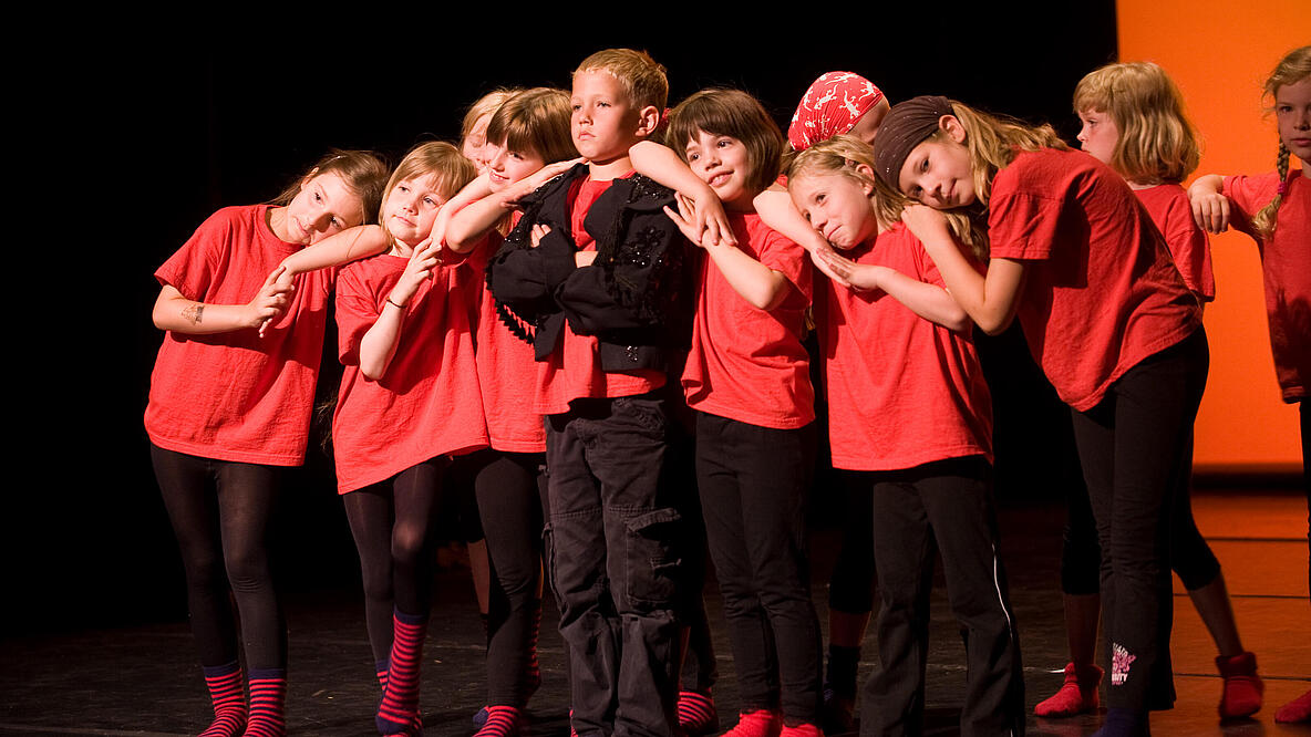 eine Gruppe von Kindern steht auf einer Theaterbühne