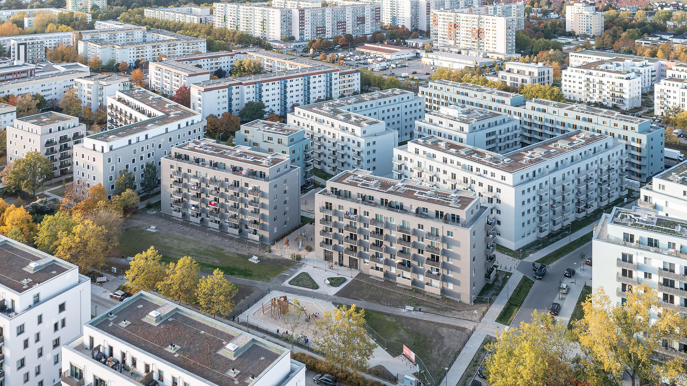 Luftaufnahme einer neugebauten Wohnanlage umgeben von Bäumen und Freiflächen