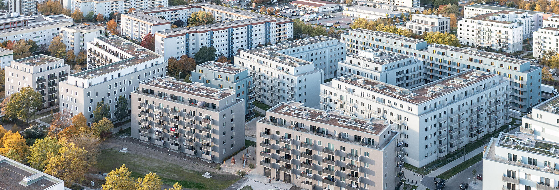 Luftaufnahme einer neugebauten Wohnanlage umgeben von Bäumen und Freiflächen