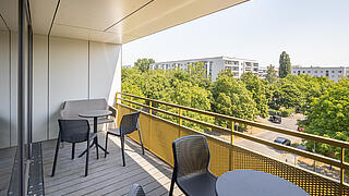 Außenaufnahme zeigt einen Balkon mit Blick auf weitere Neubauten.