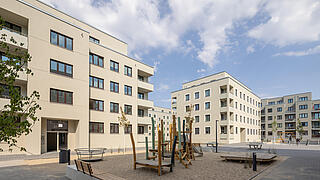 Weitläufiger und begrünter Innenhof mit Spielplatz in der Neubauwohnanlage im Quartier Stadtgut Hellersdorf.