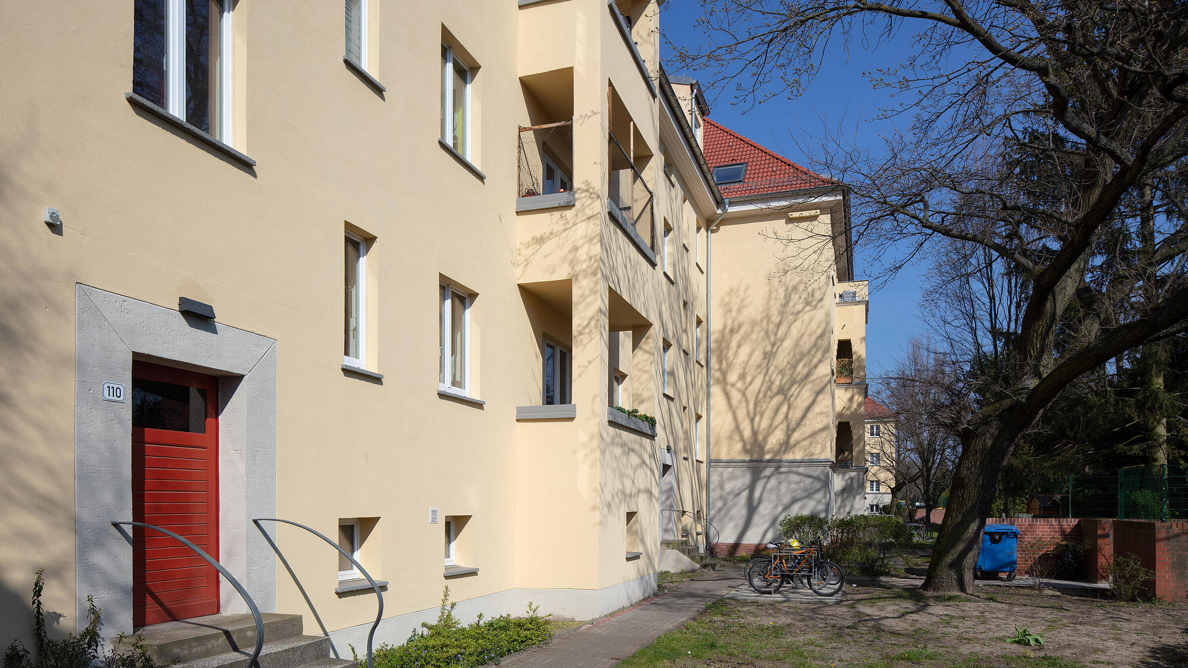 Außenaufnahme zeigt ein renoviertes Haus in der Romain-Rolland-Straße mit frischem Putz und heller Farbgebung.