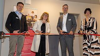 Vier Personen schneiden ein Eröffnungsband durch.