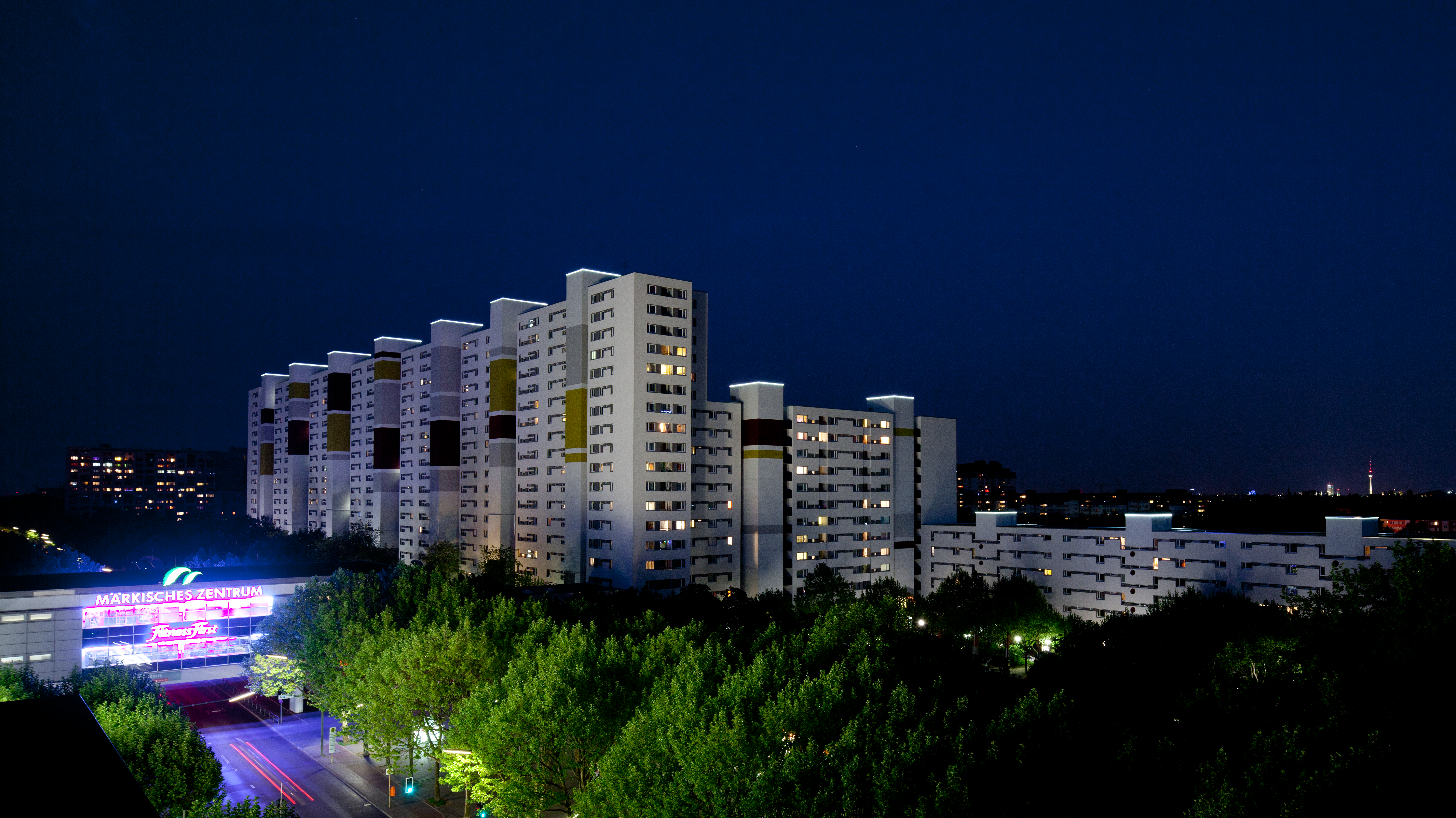Außenaufnahme zeigt die markante Silhouette des Märkischen Viertel bei Nacht, im Vordergrund links zu sehen ist das Märkische Zentrum.