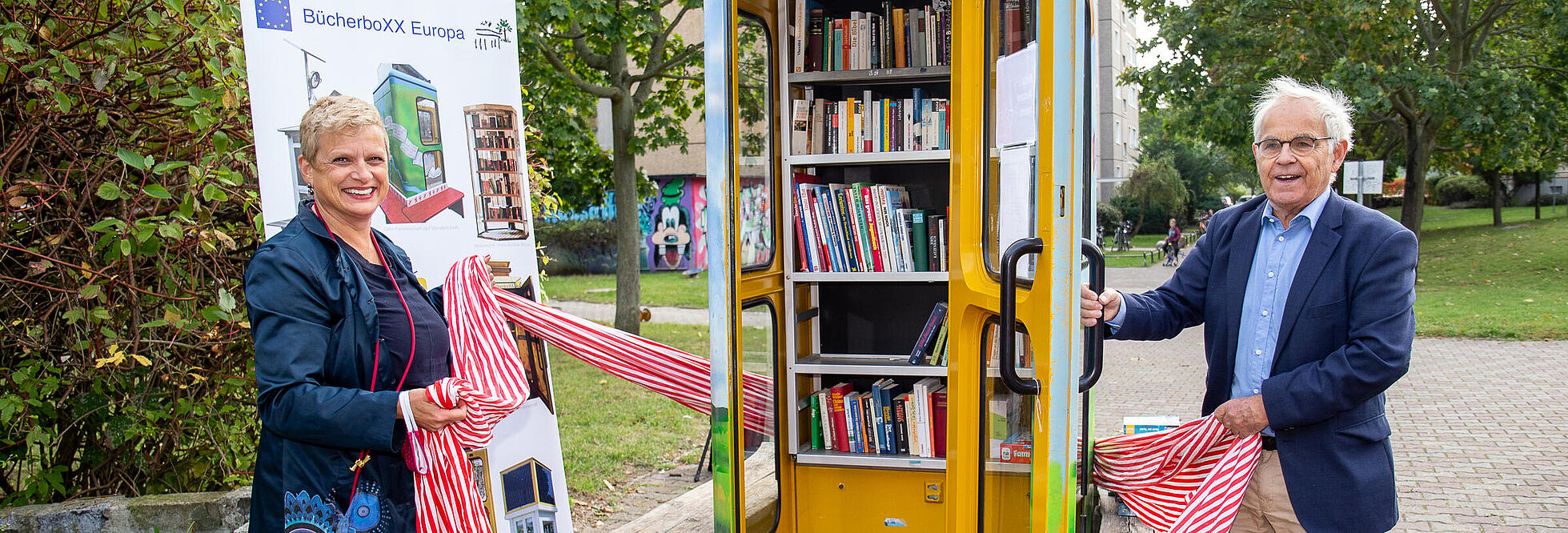 Außenaufnahme zeigt die Einweihung einer Bücherbox in Pankow: EIne bunt bemalte, ehemalige Telefonzelle wurde umfunktioniert.