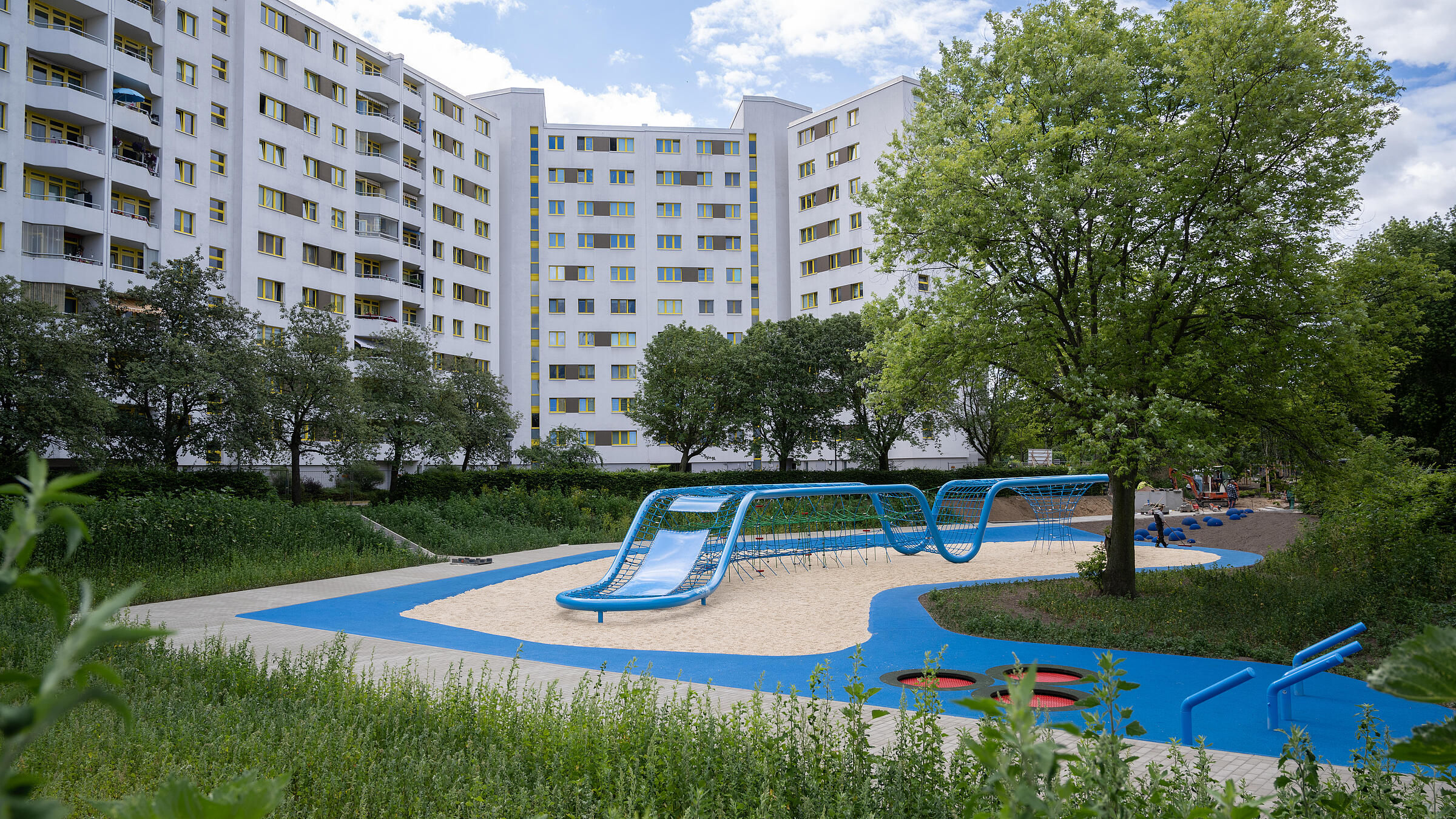 Aufnahme Außenanlage zeigt den neugestalteten Spielplatz "Wasserschlucht". Im Hintergrund Wohnhäuser der Quickborner Straße.