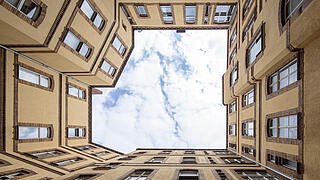 Foto zeigt den Innenhof eines Altbaus aus der Froschperspektive