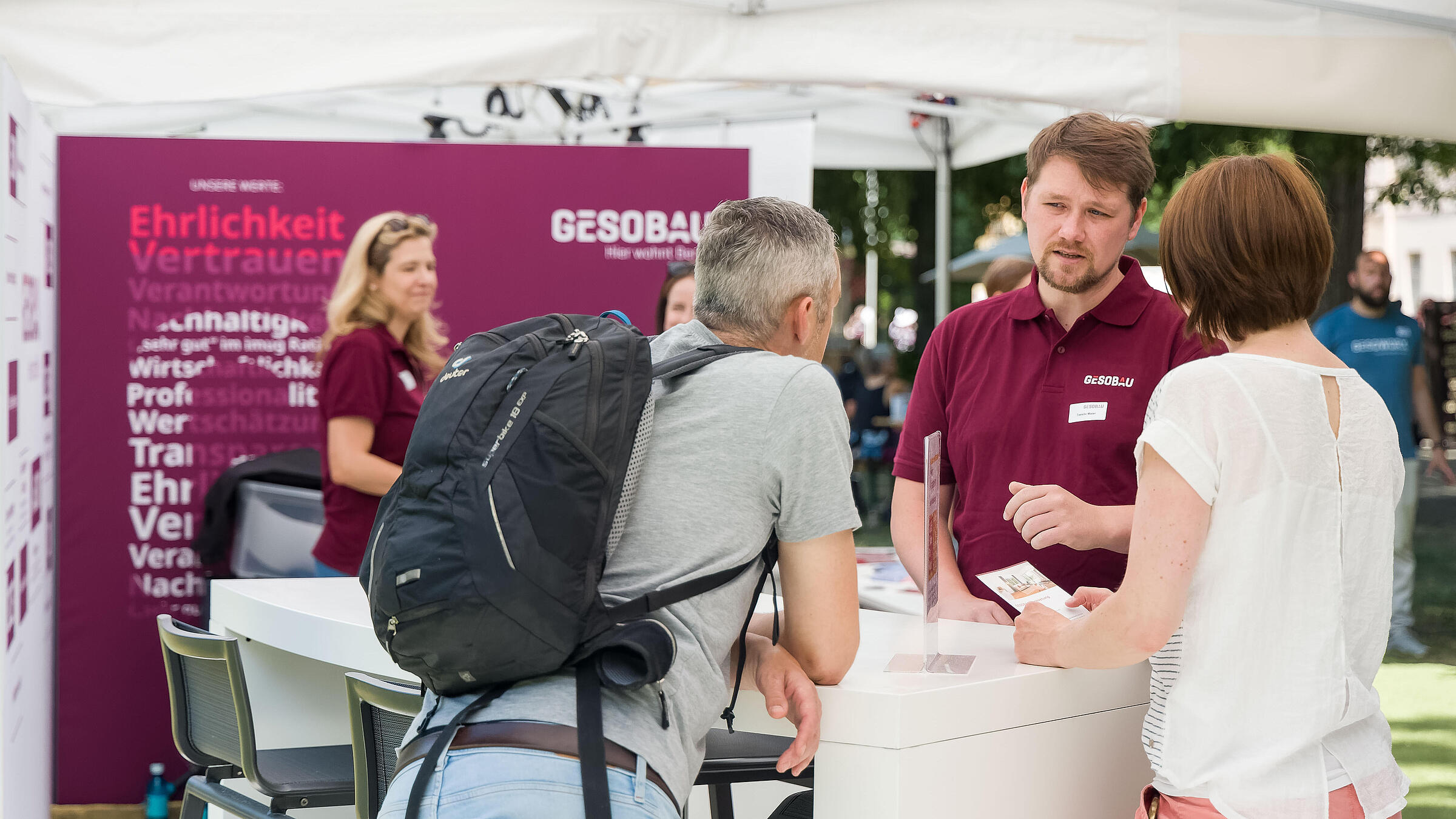 Außenaufnahme zeigt einen Mitarbeiter der GESOBAU im Gespräch mit Besucher*innen