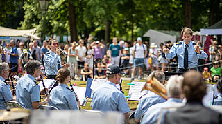 Bild zeigt Bundespolizeiorchester Berlin im Schlosspark Schönhausen, im Hintergrund Publikum und Feststände.