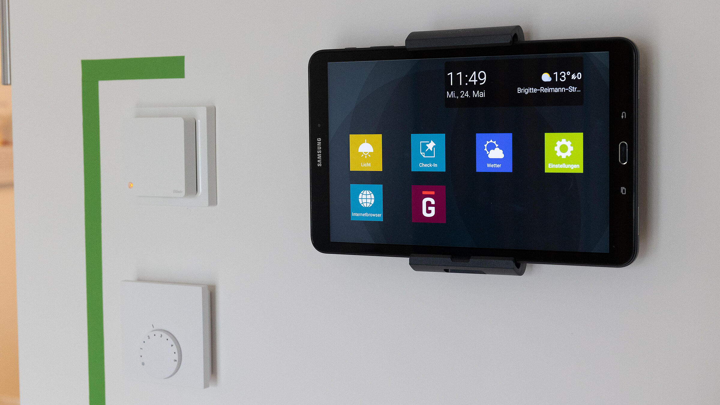Ein Tablet, das an einer Wand hängt und mit dem sich u.a. Lichtquellen in der Wohnung steuern lassen können.