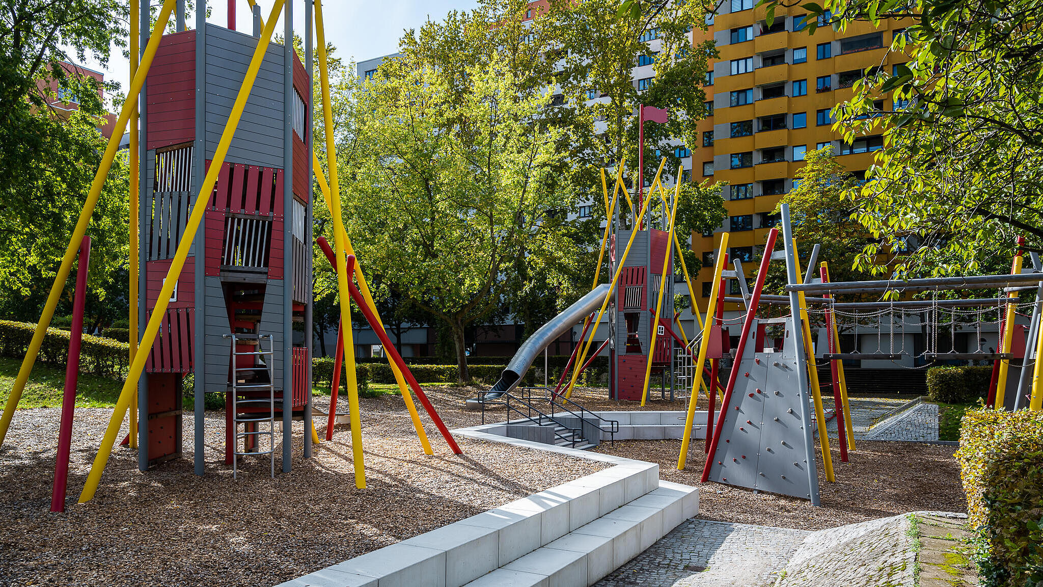 Bild zeigt Kletterspielplatz im Märkischen Viertel. Im Hintergrund Bäume und Wohnhäuser.