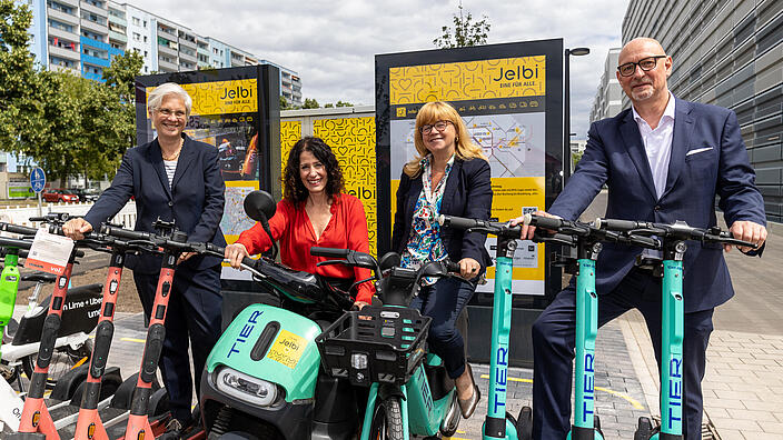 Personen mit E-Scootern und E-Rollern an einer Jelbi-Station