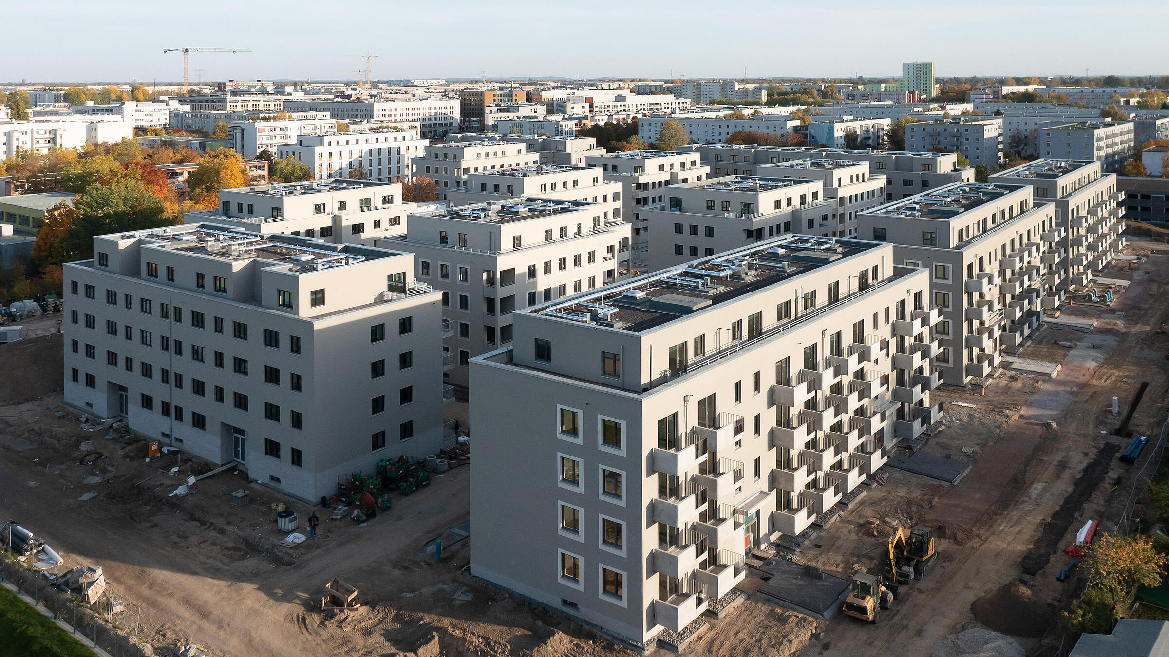 Luftaufnahme einer modernen Wohnanlage mit mehreren Wohnhäusern, die sich gerade im Bau befinden