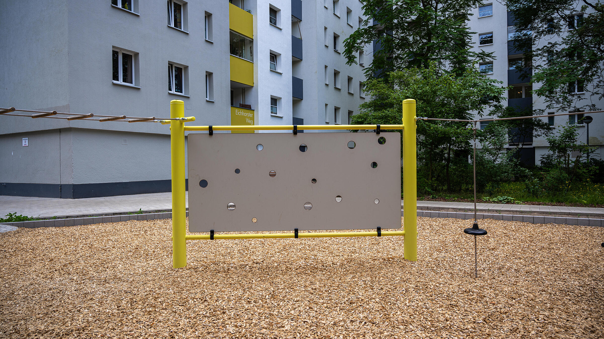 Außenaufnahme neue Kletterwand auf Spielplatz am Eichhorster Weg. Im Hintergrund Wohnhaus.