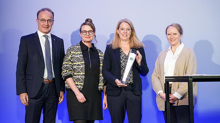 Bild zeigt Preisverleihung (Innenaufnahme): Corporate Publishing-Referentin Hélène Reick (2.v.l.) und Birte Jessen (2.v.r.), Pressesprecherin der GESOBAU, nehmen stellvertretend für das "Hallo Nachbar"-Team den Preis für Deutschlands beste Mieterzeitung von GdW-Geschäftsführer Dr. Christian Lieberknecht (l.) und der Juryvorsitzenden Prof. Dr. Annika Schach (r.) entgegen. 