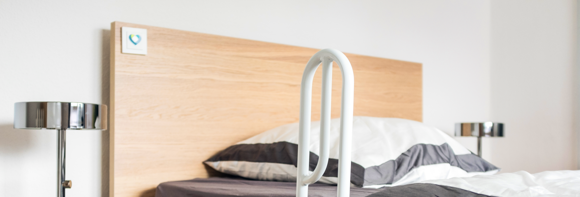 Bett mit Haltegriff und technischen Assistenzsystemen