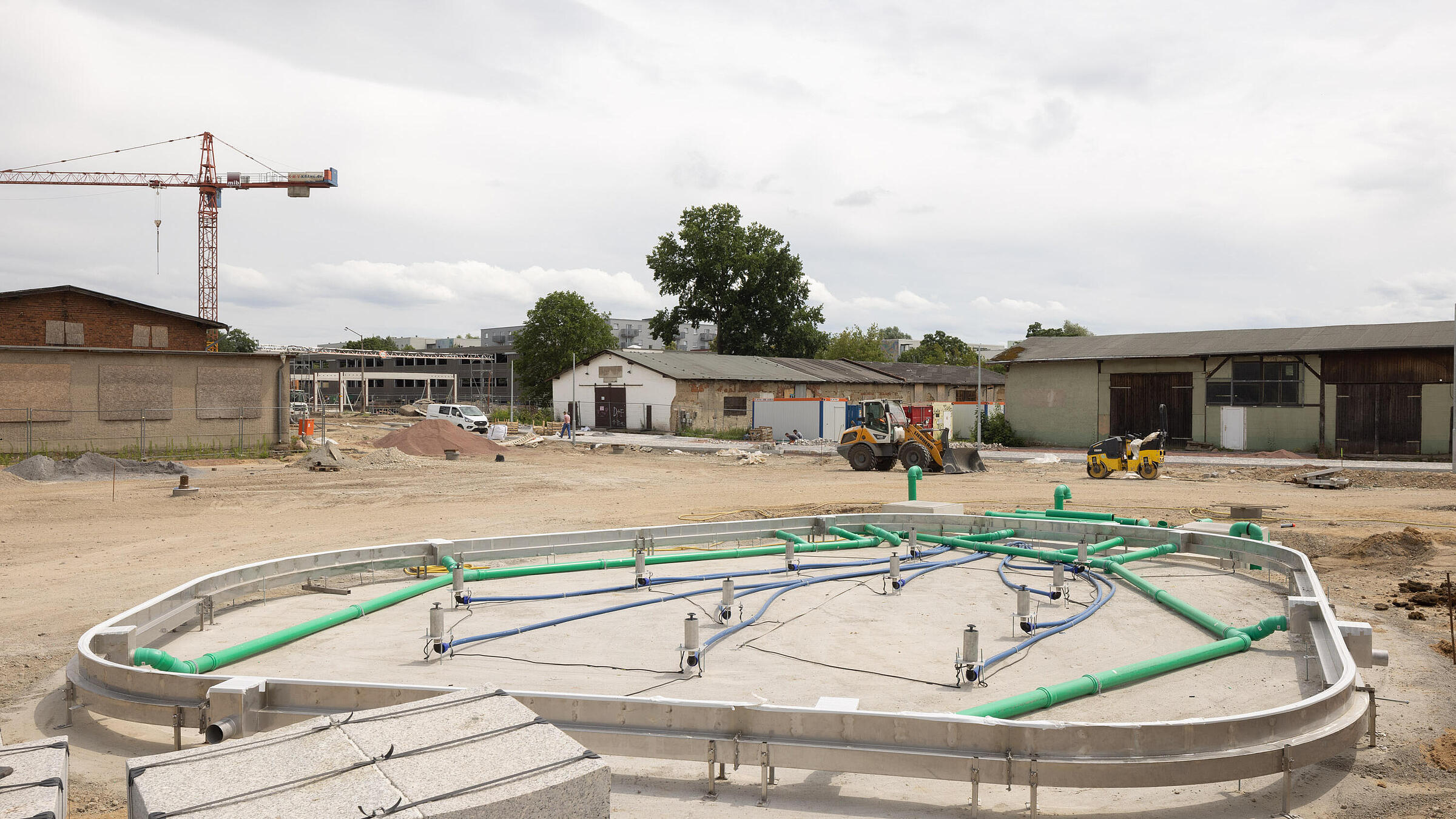 Stadtplatz im Quartier Stadtgut Hellersdorf: eine noch im Bau befindliche Fontäne umgeben von einer Sandfläche