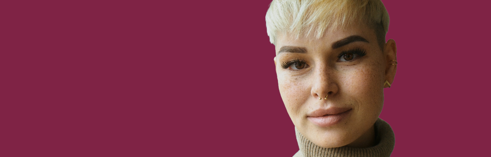 Bildausschnitt einer jungen GESOBAU-MItarbeiterin mit kurzem Haarschnitt, die lächelnd in die Kamera blickt.