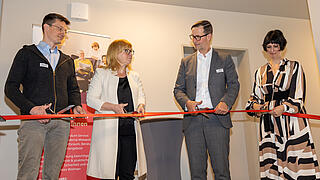 Vier Personen schneiden ein Eröffnungsband durch.