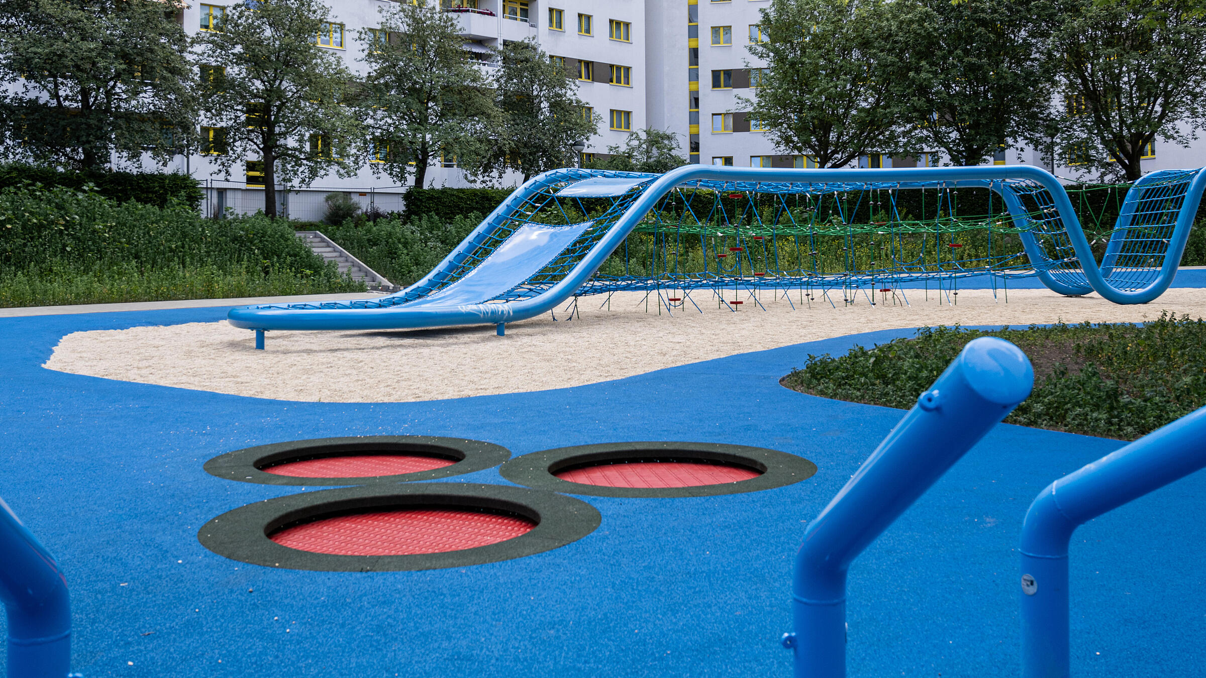 Aufnahme Außenanlage zeigt Trampoline in der "Wasserschlucht". Im Hintergrund Wohnhäuser der Quickborner Straße.