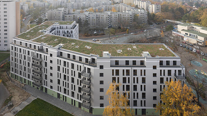 Luftaufnahme eines riegelförmigen Neubaus mit sechs Stockwerken in der Titiseestraße 7.