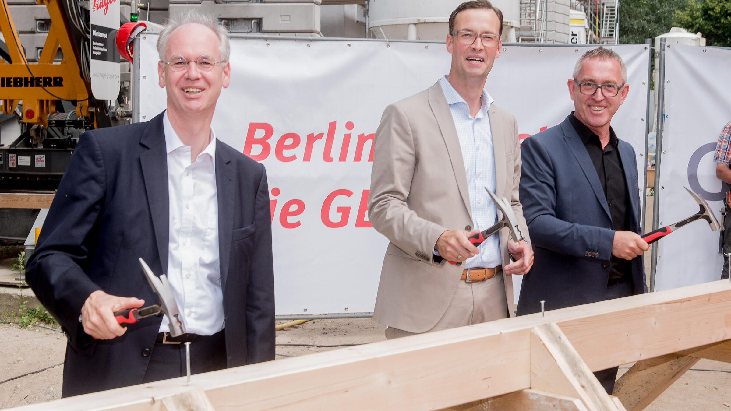 Lars Holborn, Bereichsleiter Immobilienbewirtschaftung bei der Gesobau beim Hammerschlag auf den Richtbalken